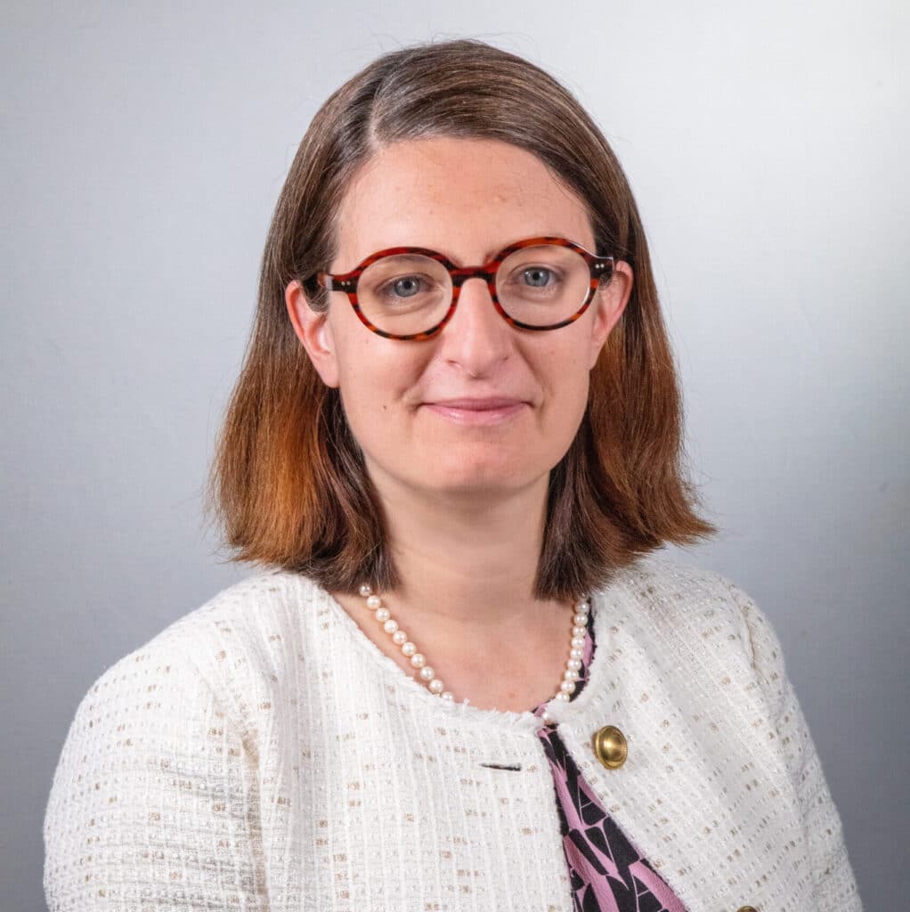 Portrait d'Isménia Revellat, Groupe ENSIO, veste blanche sur fond gris